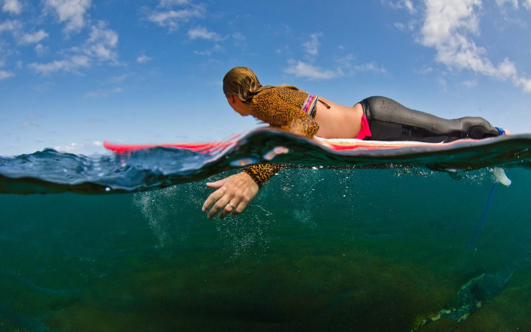 woman paddling on surfboard